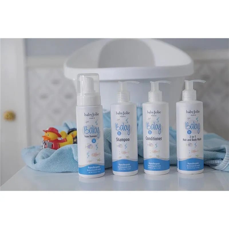 Four Baby Jolie white pump bottles including 2-in-1 hair and body wash on a blue towel with a baby tub and rubber duck.
