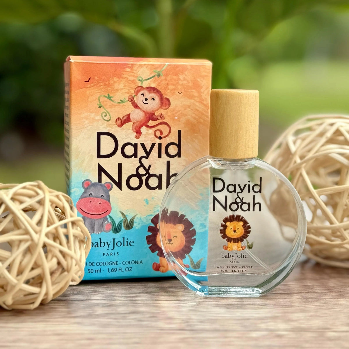 David & Noah kids perfume bottle with a wooden cap and colorful box featuring cute animal illustrations on a wooden surface.