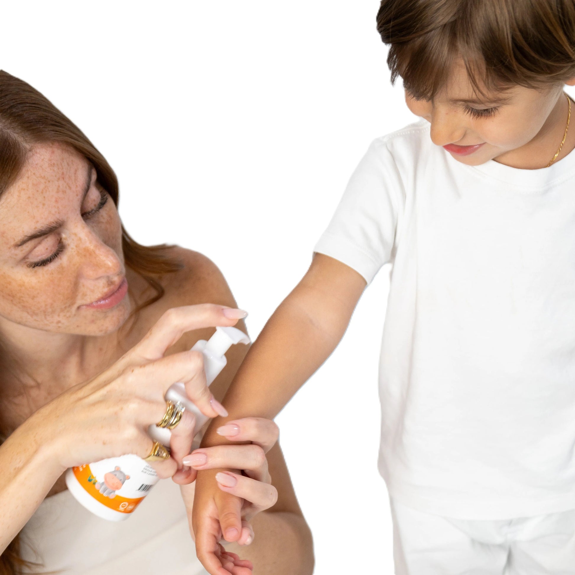 Mother applying David & Noah moisturizing lotion from a white pump bottle onto a young boy's arm.