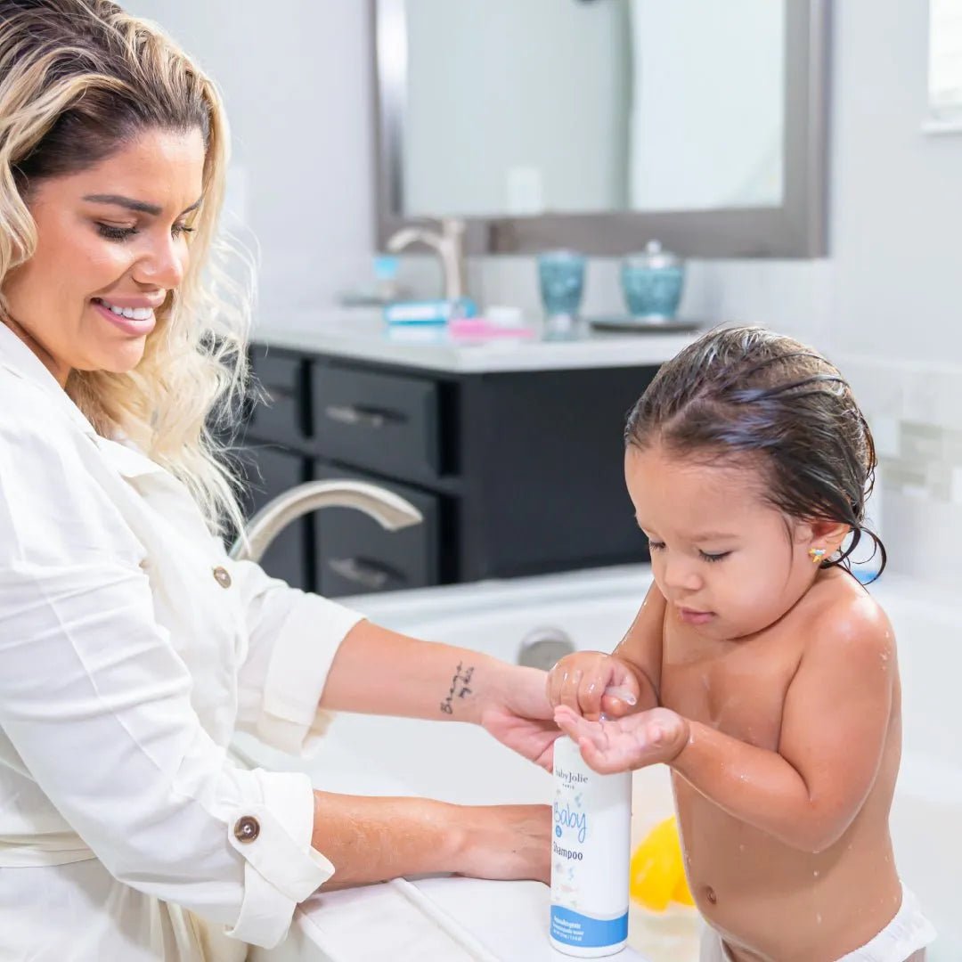 Mother helping her toddler use Baby Jolie shampoo in a bright, modern bathroom setting.